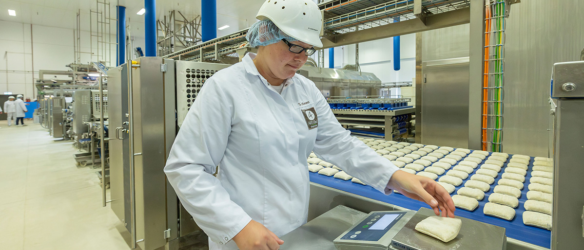 Mitarbeiterin bei Bonback im Industriepark wiegt Teiglinge.