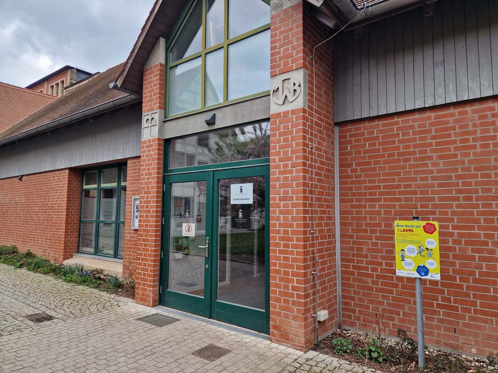 Station 2 - Franckesche Stiftungen. Tafel zum Thema Recht auf Bildung vor einem roten Backsteingebäude, rechts neben dem Haupteingang