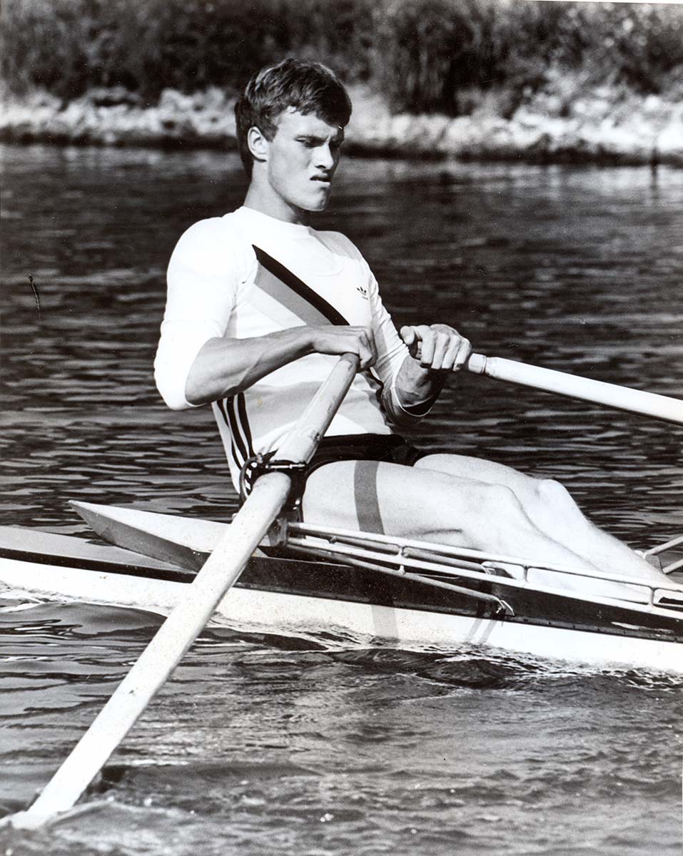 Das Foto zeigt den jungen Andreas Hajek beim Training auf dem Wasser im Einer in Nationalkleidung.