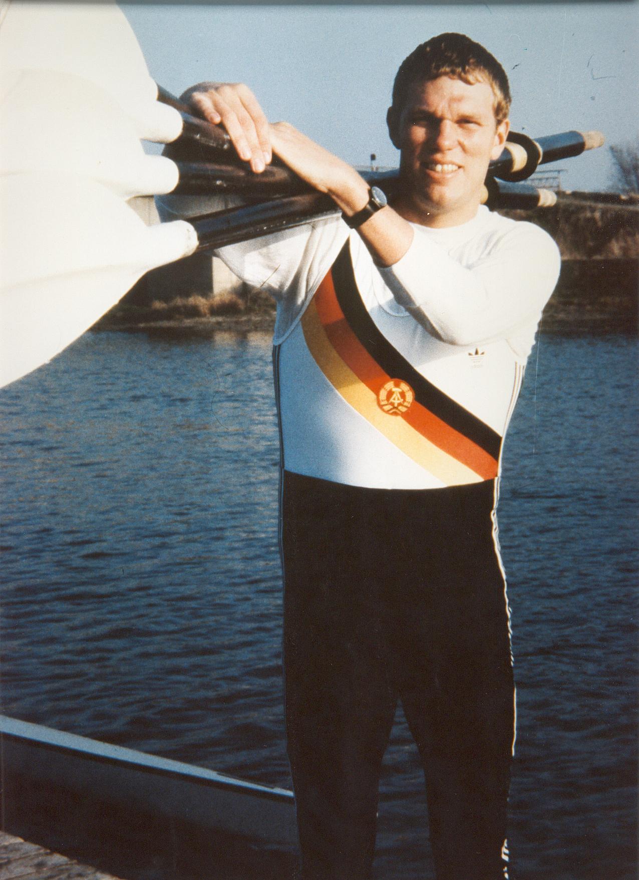 Roland Schröder steht mit vier Riemen auf der Schulter am Wasser.