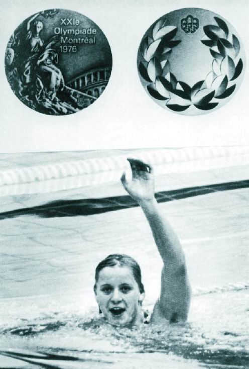 Die Schwimmerin im Becken. Sie stützt sich auf der Schwimmleine ab und hebt den linken Arm. Oben im Bild ist ihre Olympiamedaille abgebildet.