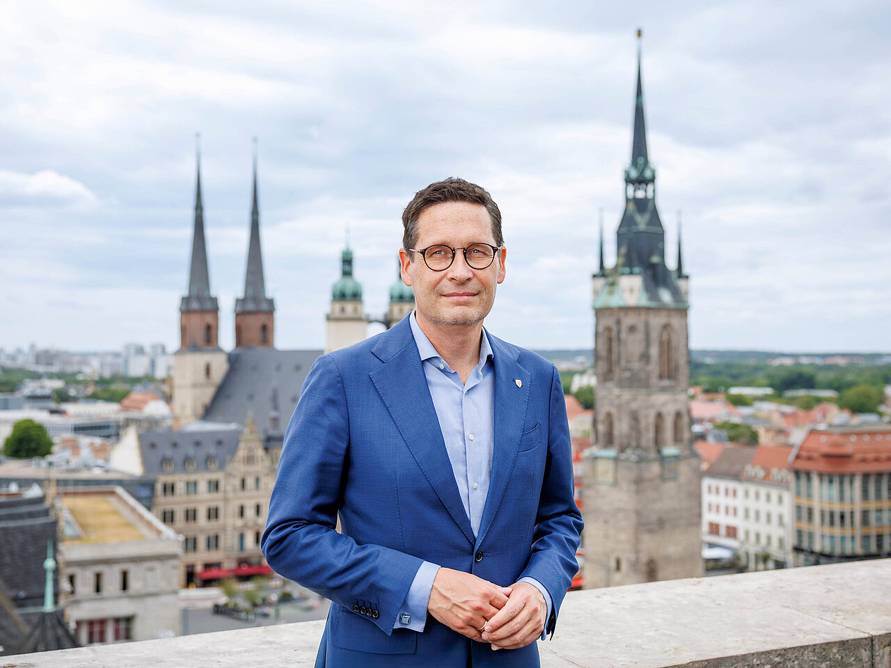 Porträtfoto Oberbürgermeister Dr. Alexander Vogt mit Markt von Halle im Hintergrund