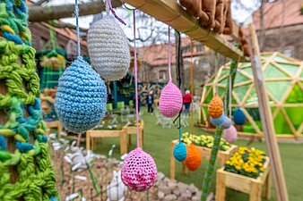 Gehäkelte Ostereier an einem Holsbalken aufgehängt