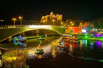 beleuchtete Boote, im Hintergrund die beleuchtete Giebichensteinbrücke und Oberburg Giebichenstein
