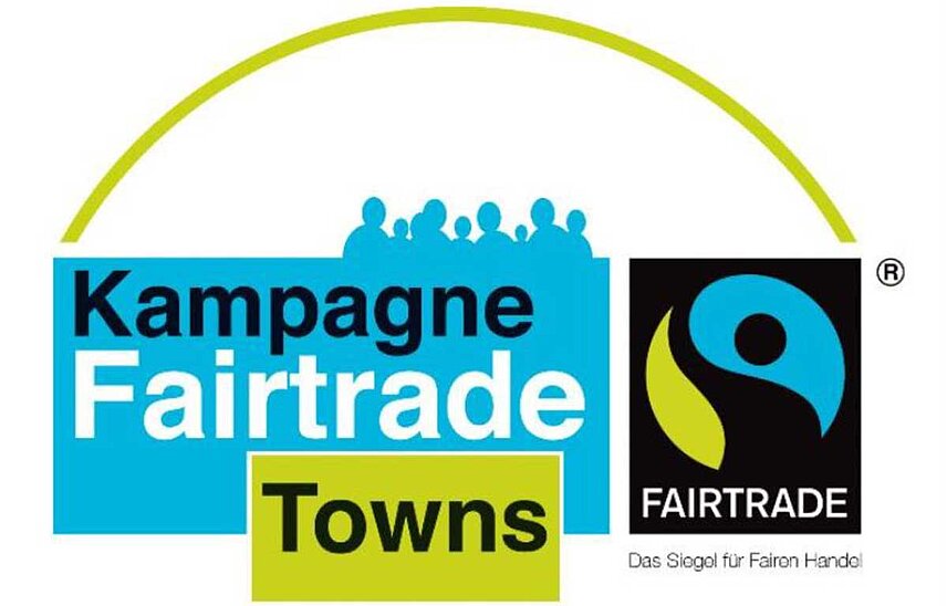 Das Logo: Blaue und hellgrüne Rechtecke mit Beschriftung "Kampagne Fairtrade Towns", menschliche Silhouetten