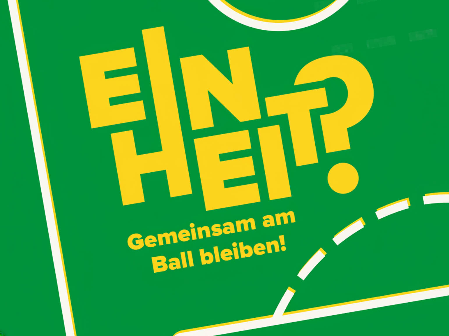 grüner Untergrund wie ein Fußballfeld, darauf die Schrift Einheit? Gemeinsam am Ball bleiben!