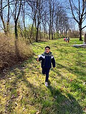 Kleiner Junge kommt mit Streumüll in der Hand angelaufen.