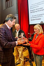 Brigitte Schuster, geehrt für ihr Engagement beim Seniorenbesuchsdienst Klingelzeichen, erhält ein Präsent und ihre Ehrenamtskarte.