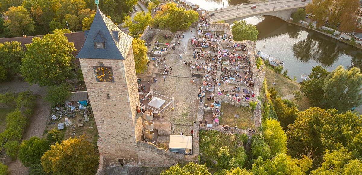 Blick von oben auf das Gelände der Oberburg Giebichenstein mit vielen Besuchern
