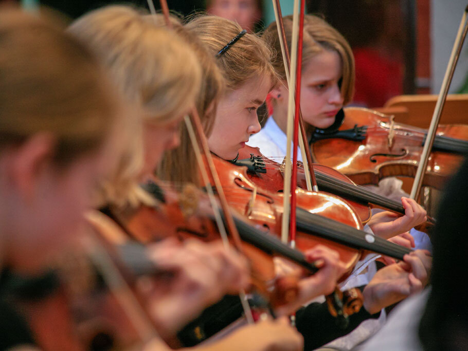 Junge Musikerinnen des Konservatoriums musizieren auf Geigen