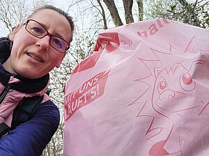 Foto zeigt die Privatperson mit einem Frühjahrsputz-Müllsack daneben.