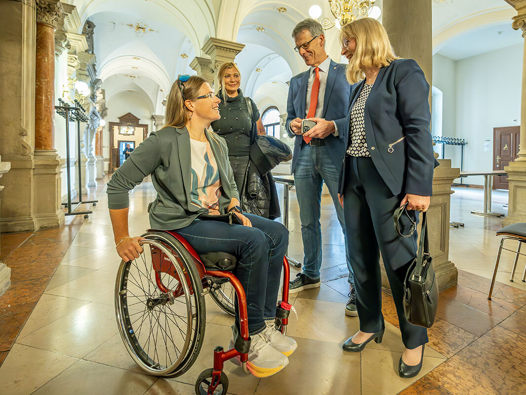 Anja Adler - hallesche Medaillengewinnerin bei den Paralympischen Spielen 2024 in Paris im Rollstuhl sitzend wird von Bürgermeister Egvert Geier und der Beigeordneten für Kultur und Sport, Dr. Judith Marquardt, im Stadthaus empfangen 