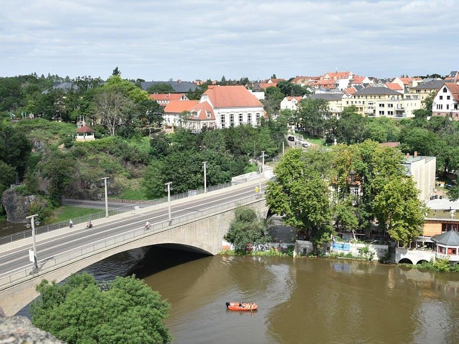 Bogenbrücke über dem Fluss, kleines Boot, Häuser am Ufer