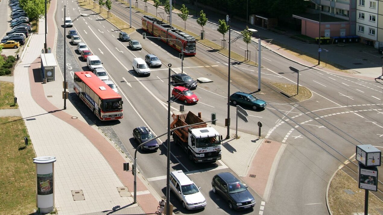 Bild einer Straße mit Autos, Bus, Straßenbahn und Lastkraftwagen