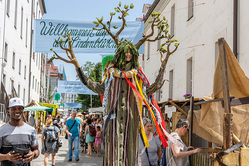 Eine als Linde verkleidete Frau geht durch den Markt im Innenhof der Franckeschen Stiftungen