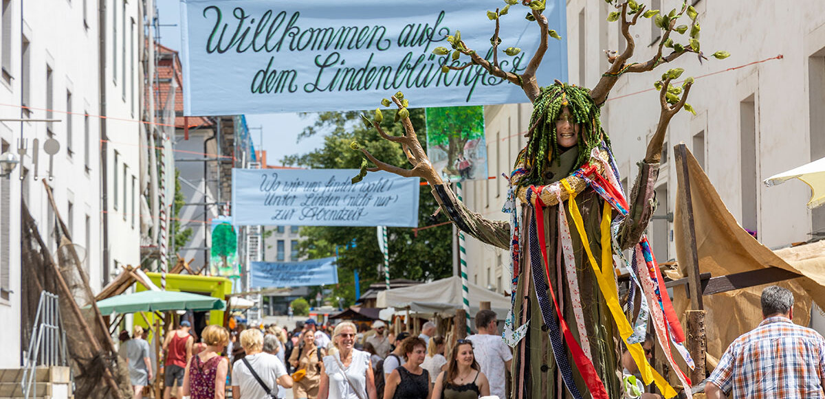 Eine als Linde verkleidete Frau geht durch den Markt im Innenhof der Franckeschen Stiftungen