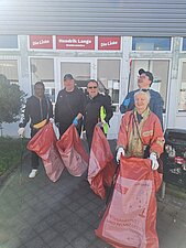 Foto auf dem alle beteiligten Wahlkreismitarbeiter vor dem Wahlkreisbüro zu sehen sind. Alle halten Frühjahrsputz-Müllsäcke in der Hand.