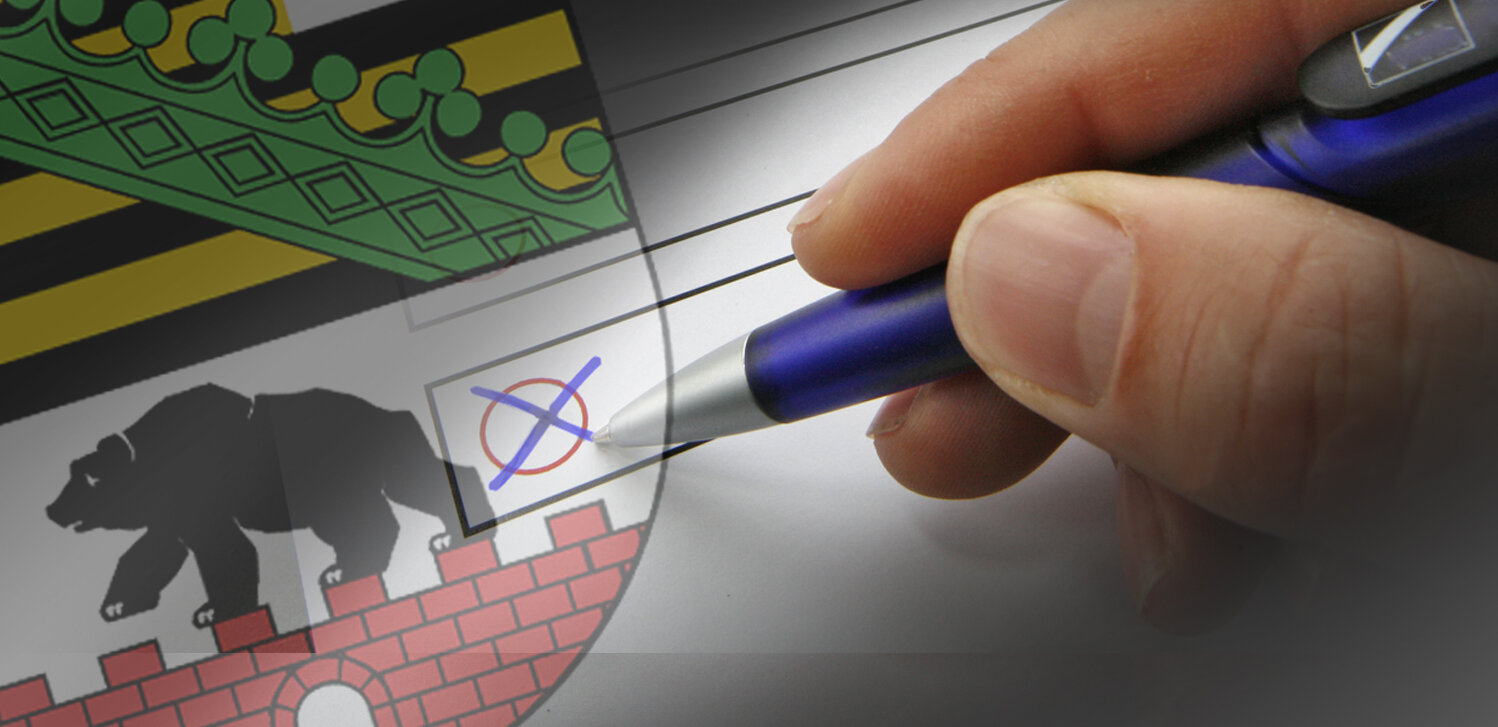 Wappen Sachsen-Anhalt, Hand mit Stift setzt Kreuz auf Wahlzettel