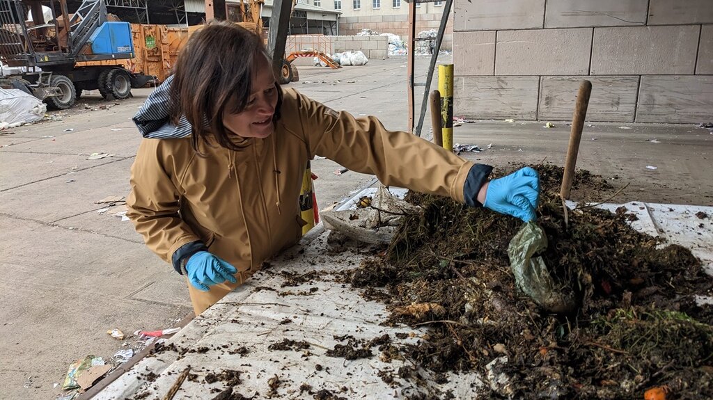 Frau sortiert Plastik aus dem Biomüll