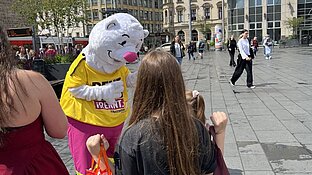 ein großer weißer Bär mit pinker Hose spricht mit Kindern über die Abfalltrennung