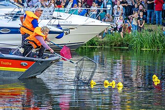 Die Siegerente des Entenrennens wird von Frau Dr. Marquardt aus dem Wasser gefischt