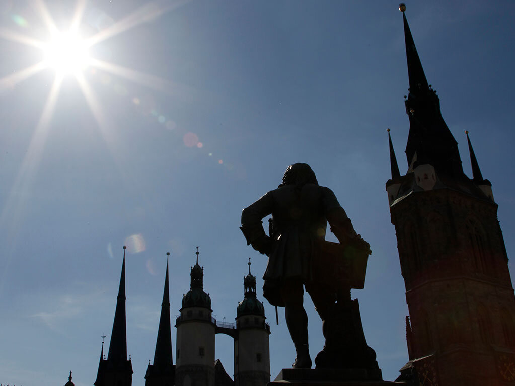 Silhouette von der Marktkirche, den Hausmannstürmen und dem Händel-Denkmal gegen die Sonne fotografiert