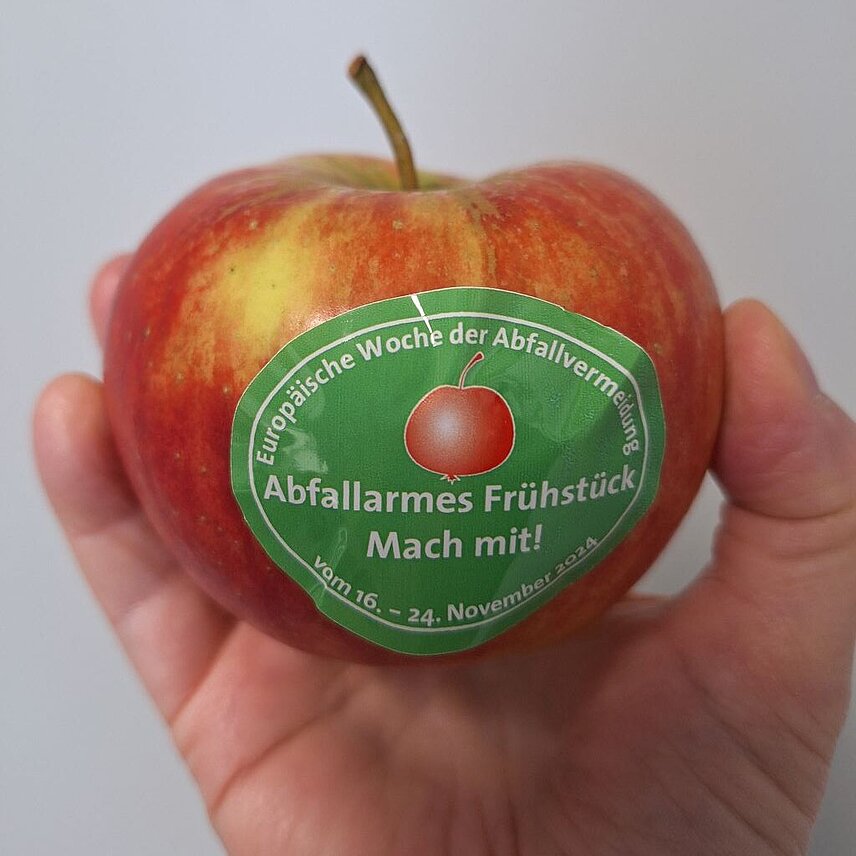 Apfel in einer Hand mit einem Aufkleber