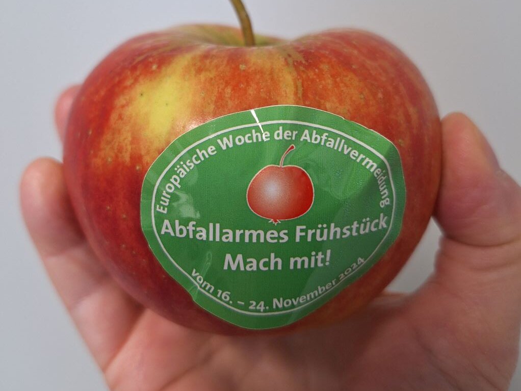 Apfel in einer Hand mit einem Aufkleber