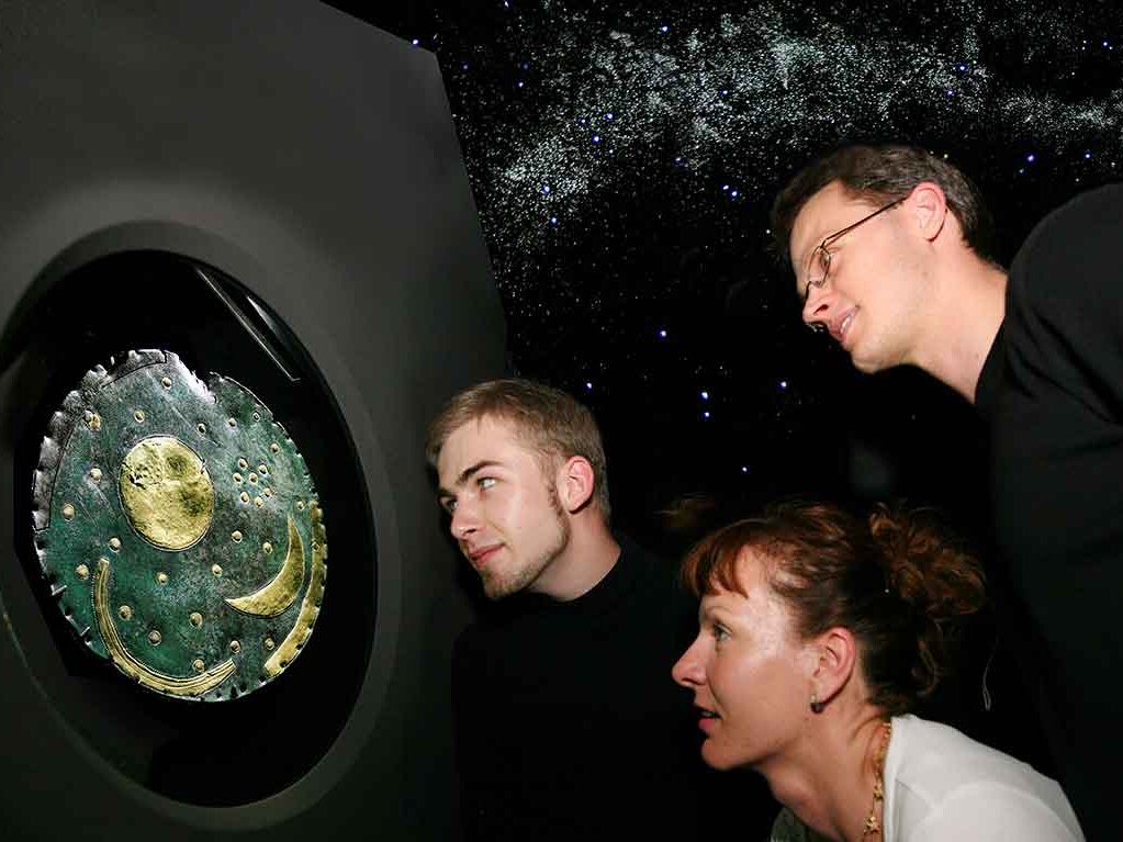 Besucher betrachten die Himmelsscheibe von Nebra, eine kreisförmige Bronzeplatte mit Applikationen aus Gold mit der ältesten bekannten konkreten Himmelsdarstellung