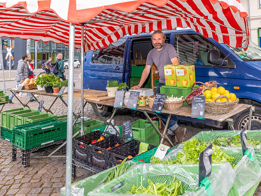 Anbieter von Gemüse an seinem Stand auf dem Bioabendmarkt