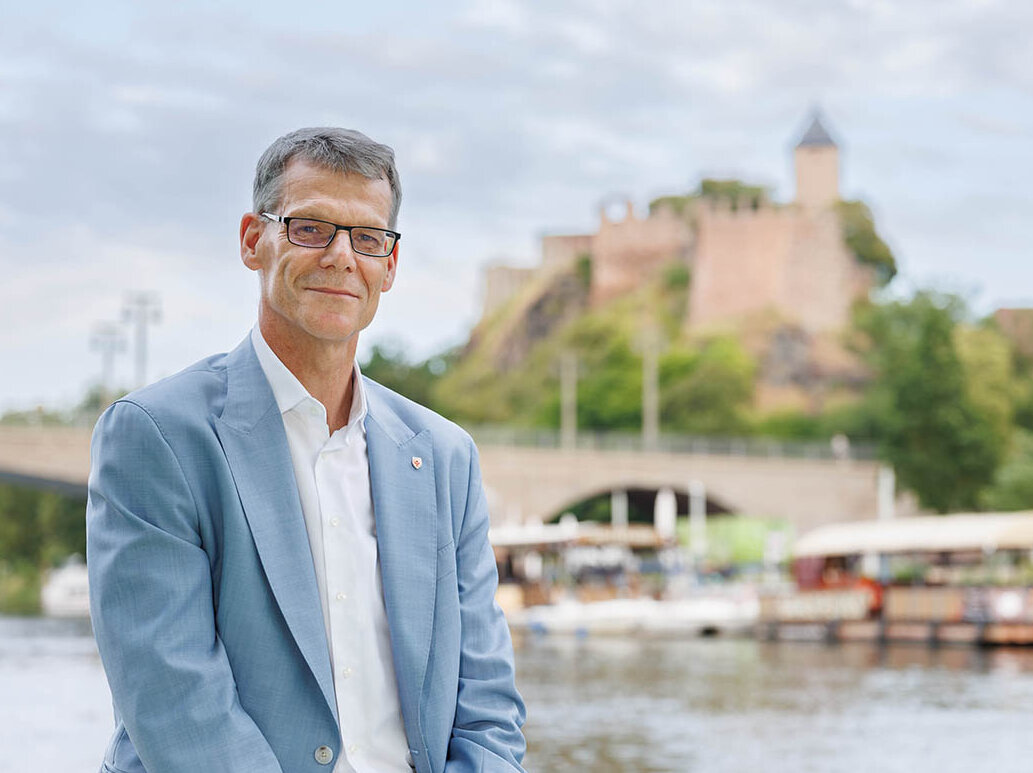 Porträtbild von Egbert Geier, im Hintergrund die Saale und die Burg Giebichenstein