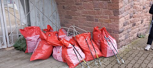 Foto auf dem mehrere befüllte Müllsäcke zu sehen sind, die am Torbogen des Stadions abgestellt wurden.