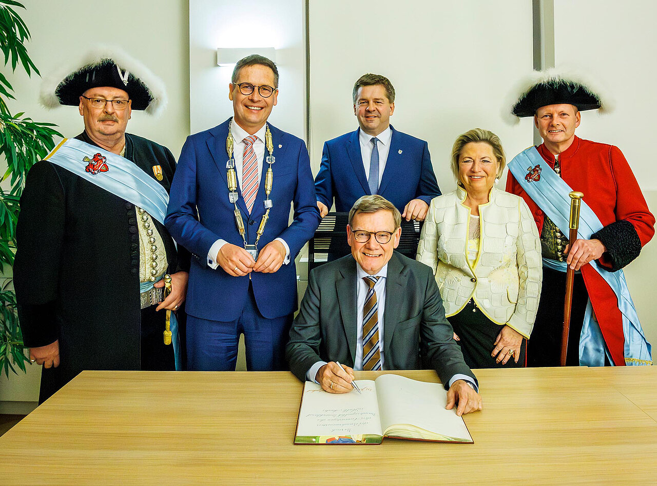 Von zwei Halloren eingerahmt (von links): Oberbürgermeister Dr. Alexander Vogt, Bundesaußenminister Dr. Johann Wadephul, am Tisch sitzend, beim Eintrag in das Goldene Buch der Stadt, Ministerpräsident Sven Schulze und Cornelia Pieper, Staatsministerin a.D. und Vorsitzende der Hans-Dietrich Genscher-Stiftung