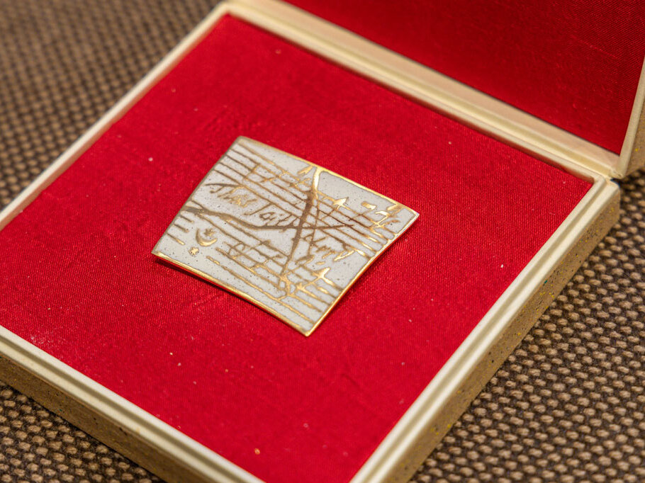 Die Anstecknadel des Händel-Preises ist eine aus Gold und Emaille gefertigte Nadel, die einige Notenmotive aus dem Händelschen Oratorium „Messias“ zeigt.