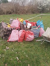 Foto von mehreren befüllten Müllsäcken, die auf einer Grünfläche abgestellt wurden.