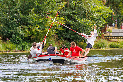 2 Halloren auf Booten stooßen sich mit großen Stangen gegenseitig ins Wasser