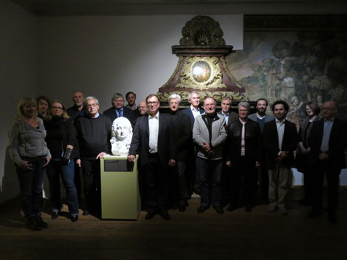 Eine Gruppe von 18 Männern und Frauen steht in einem historischen Zimmer des Christian Wolff-Hauses (Stadtmuseum)