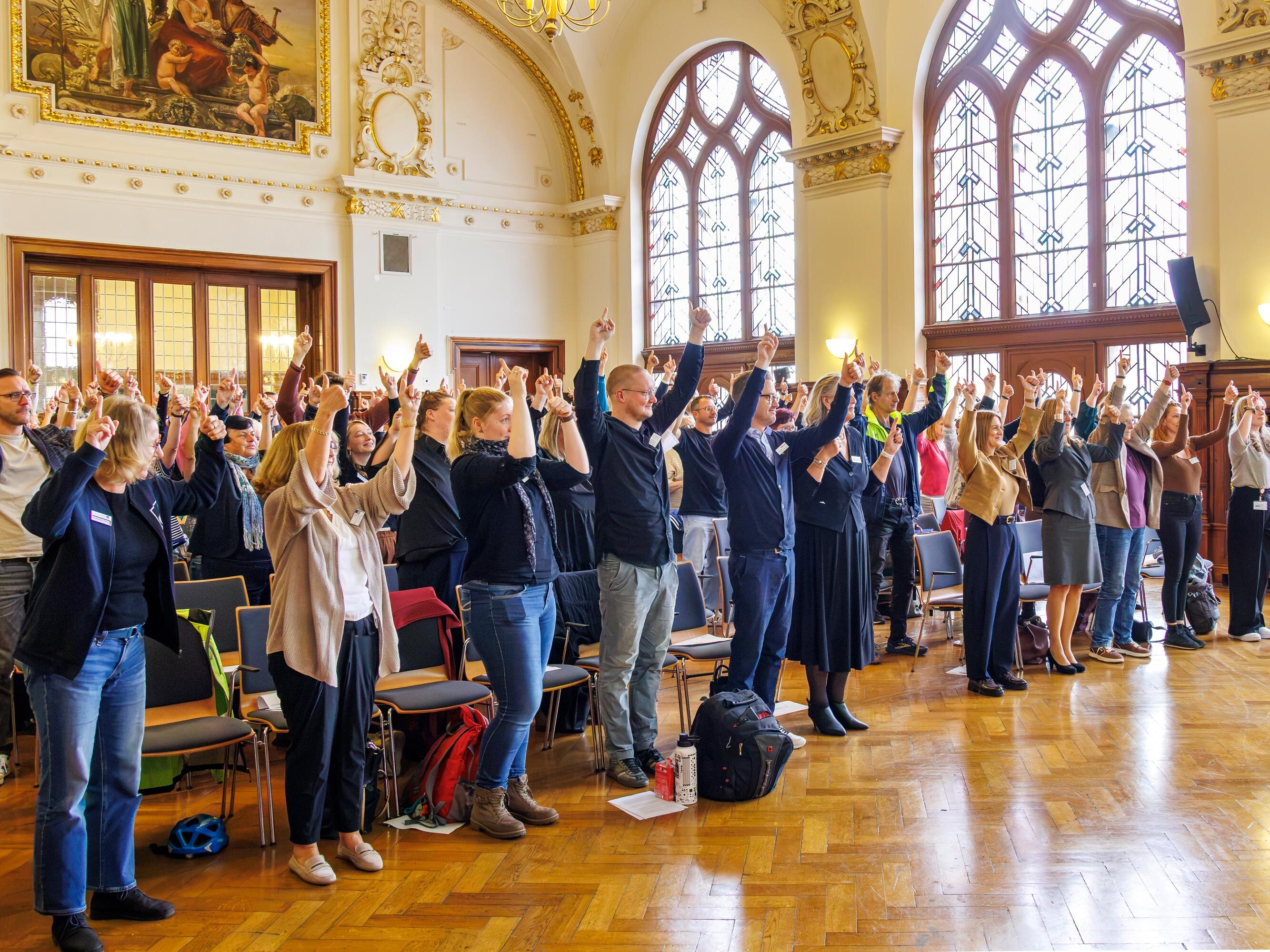 Teilnehmende der 4. Kommunalen Gesundheitskonferenz während einer gemeinsamen Aktivpause im Stadthaus Halle (Saale)