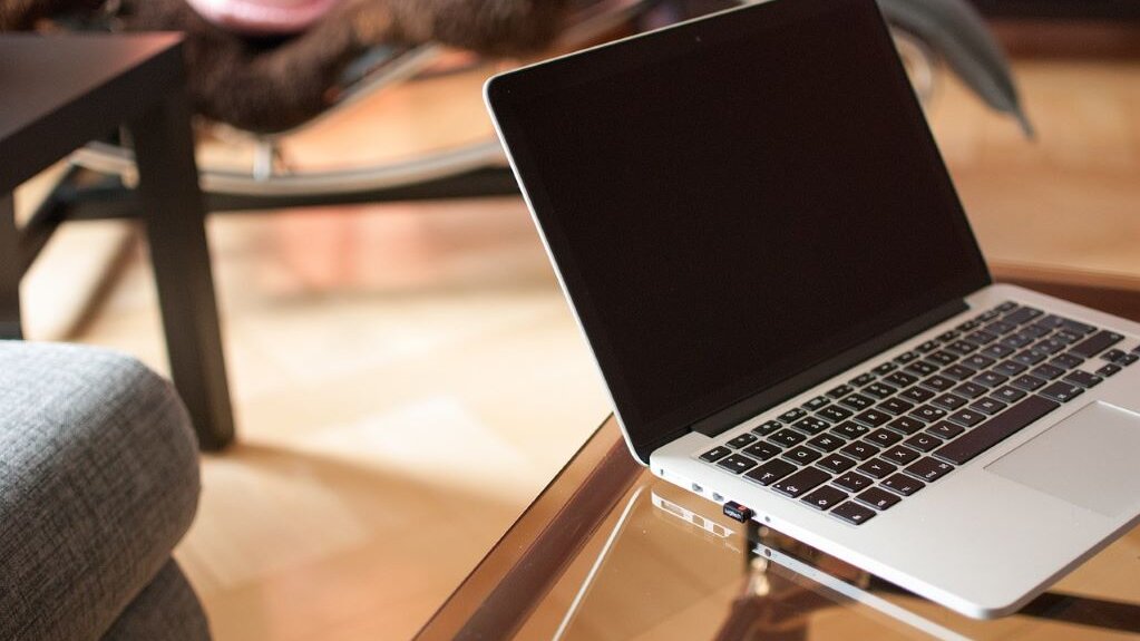 ein offener Laptop steht auf einem Glastisch