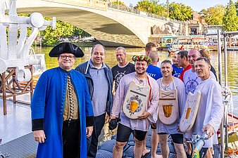 Sieger beim Fischerstechen trägt einen Blumenkranz
