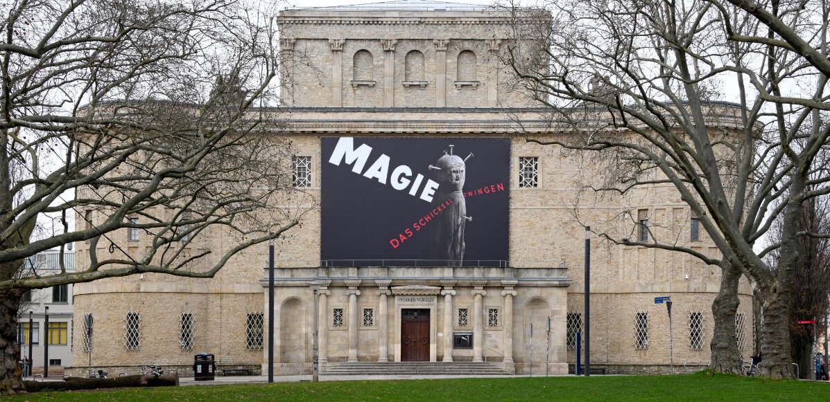 Außenansicht Landesmuseum für Vorgeschichte mit Plakat zur Ausstellung "Magie – Das Schicksal zwingen“