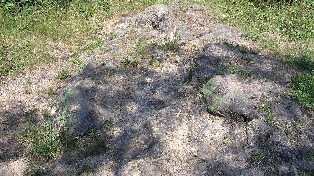 Felsen mit vereinzelten grünen Pflanzen und Bäumen