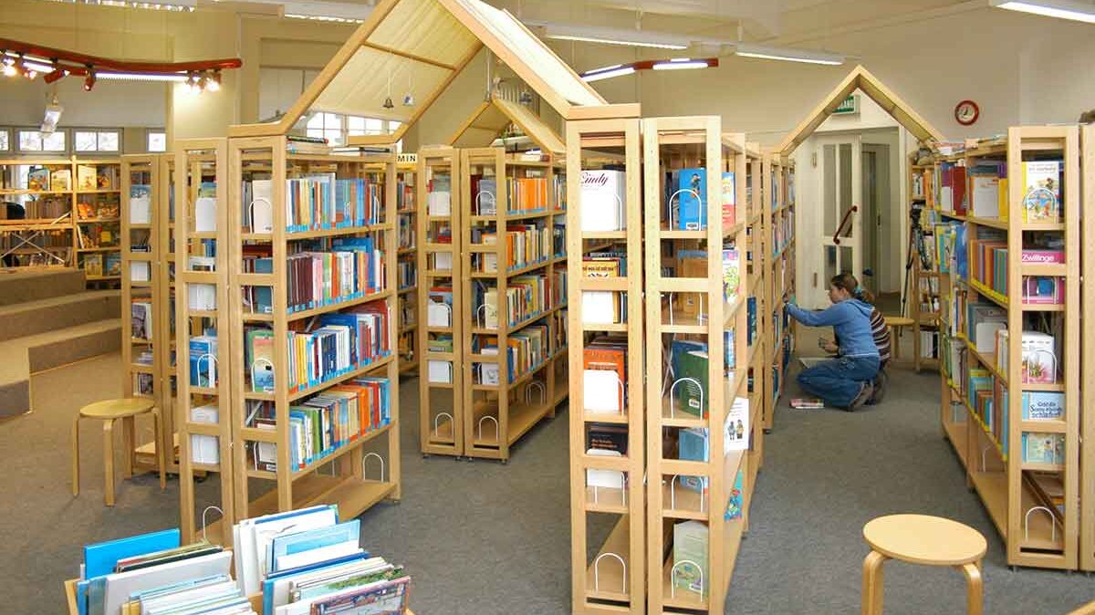 Bücherregale voller Bücher mit lesendem Kind
