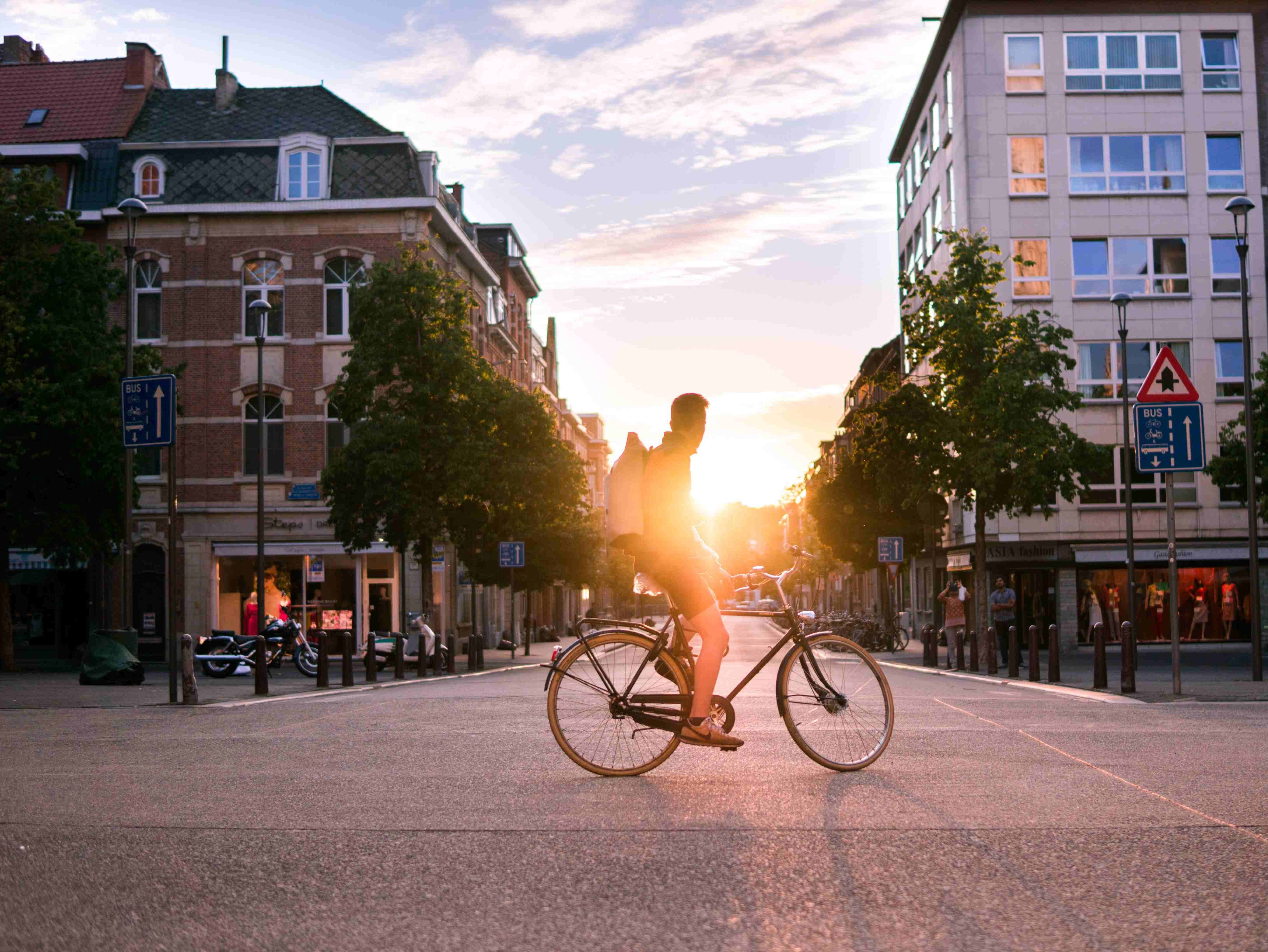 Ein junger Mann fährt Rad durch die Stadt bei Sonnenuntergang