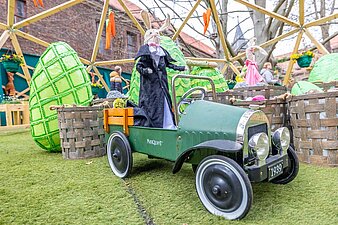 Osterhase in einem großen Spielzeugauto aus Blech mit Aufschrift 1939
