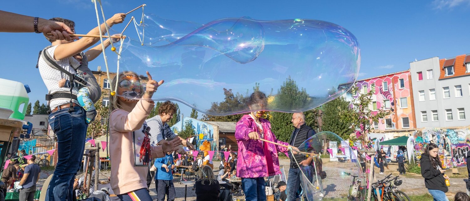 Kinder machen Seifenblasen und fahren mit den Rädern auf der Straße