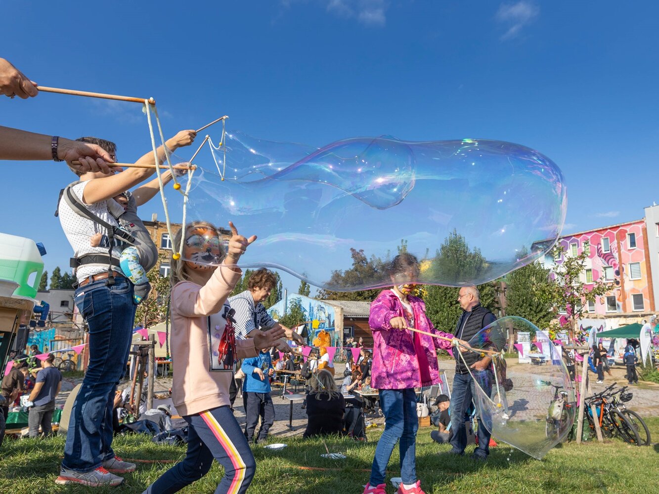Kinder machen Seifenblasen und fahren mit den Rädern auf der Straße