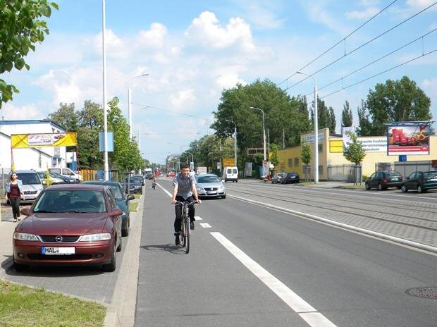 Fahrradfahrer auf einem Radfahrstreifen parallel zur Straße mit Autoverkehr