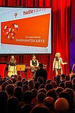 Die Musiker von Poet stehen auf der Bühne, singen und spielen Instrumente.
