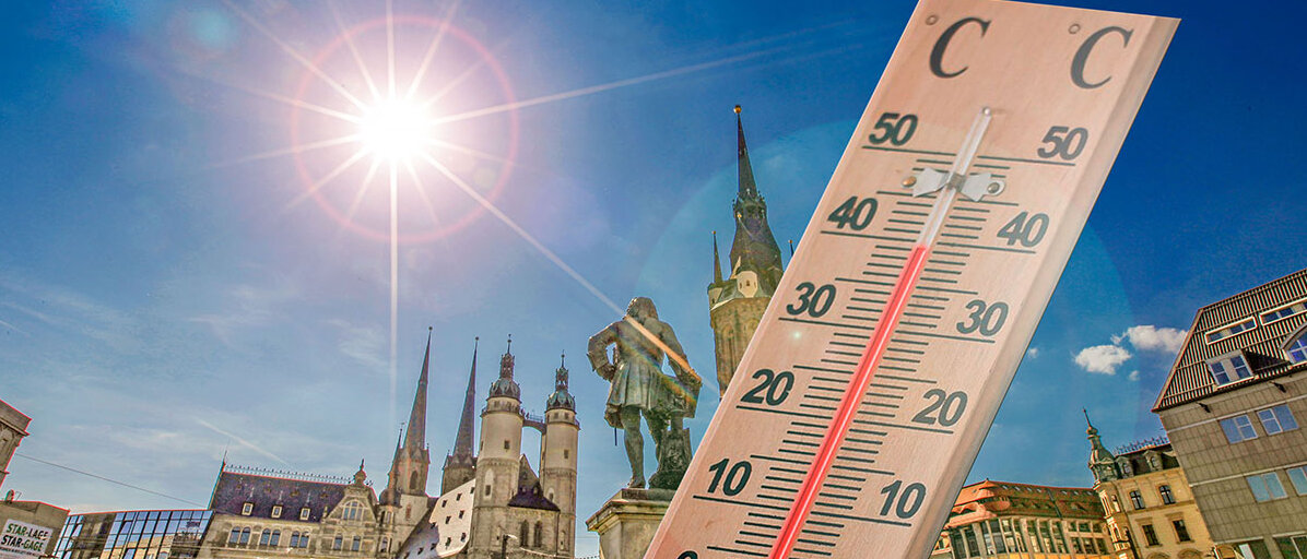 Holzthermometer zeigt fast 40 Grad an, im Hintergrund der Marktplatz von Halle